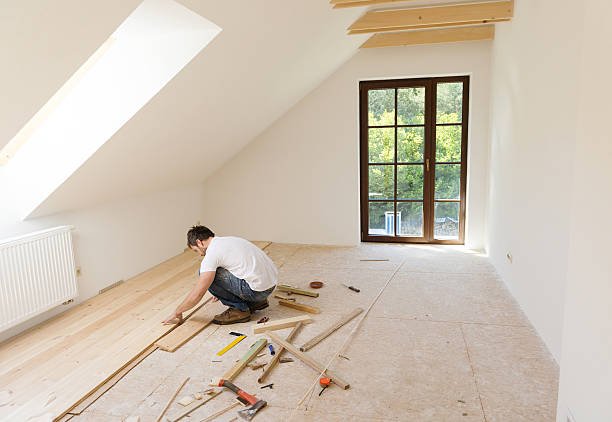 Handyman installing wooden floor in new house